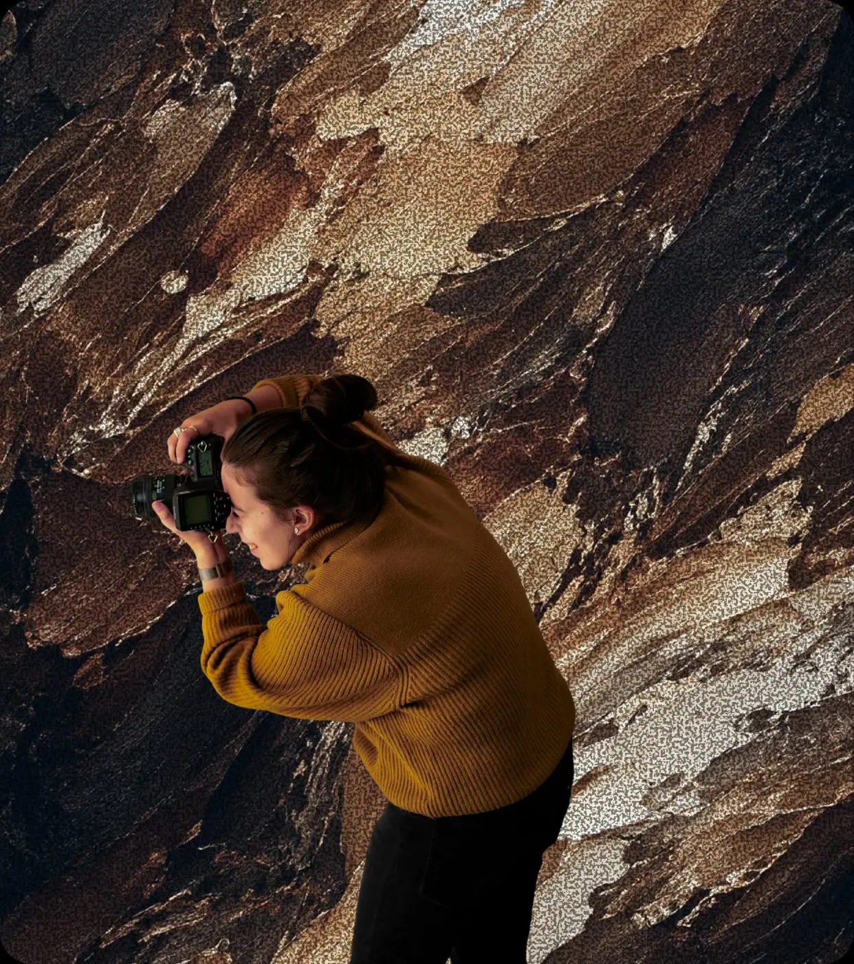 Fotógrafa disparando apoyada sobre una roca